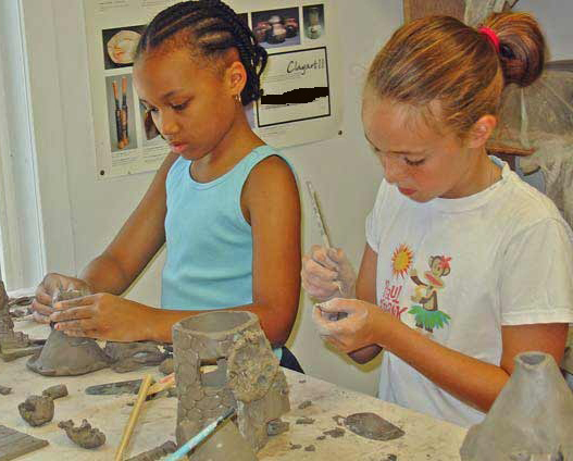 kids making pottery at a table